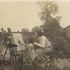 Girl painting in garden, mother looking