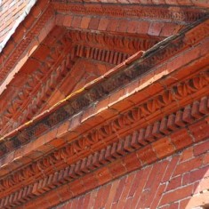 The intricate brickwork of the pediment over the front door.
