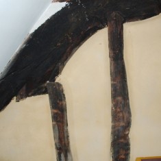 Truss beam seen from a bedroom on the other side of the wall. This was revealed in 2009, and is deemed to be fine by the standards of carving in the early 14th century. 
