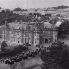 Main house in 1950s, with naval parade taking place in front of it. The first semi-permanent buildings to be constructed commenced in April 1944 and were the classrooms of North Camp.. The Navy requisitioned the property in 1945 and bought Leydene House in 1949. 