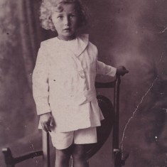 Small boy with curly hair Reg as a child.