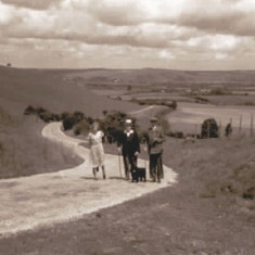 Threesome walking up Leydene hill, East Meon in background.