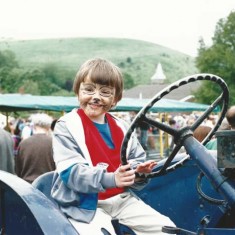 Boy driving vintage tractor