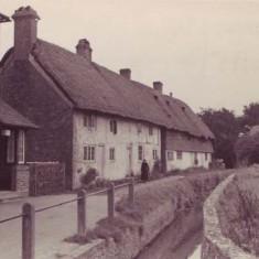 Hockley Cottage and narrow river. Old lady in black.