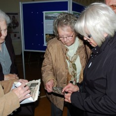 Ladies discussing the photos they have brought for archiving.