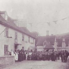 Staff and villagers gather outside the George Inn at a celebration, possibly Queen Victoria's Jubilee in 1887.