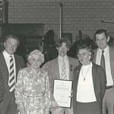 Presentation by Atkinsons to Ginger Phillips. L to R, Eileen A, Wilson A, Sarah (Wilson's mother), Ginger Phillips with certificate, Kate, Michael and Jane Atkinson