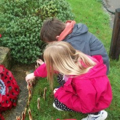 Two pupils placing crosses at War Memorial